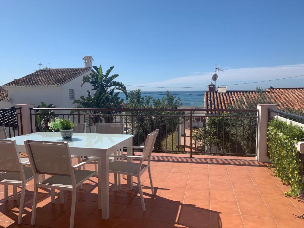 einen weißen Tisch und Stühle auf dem Balkon in der Unterkunft El Rincón de Cristina in Torre de Benagalbón