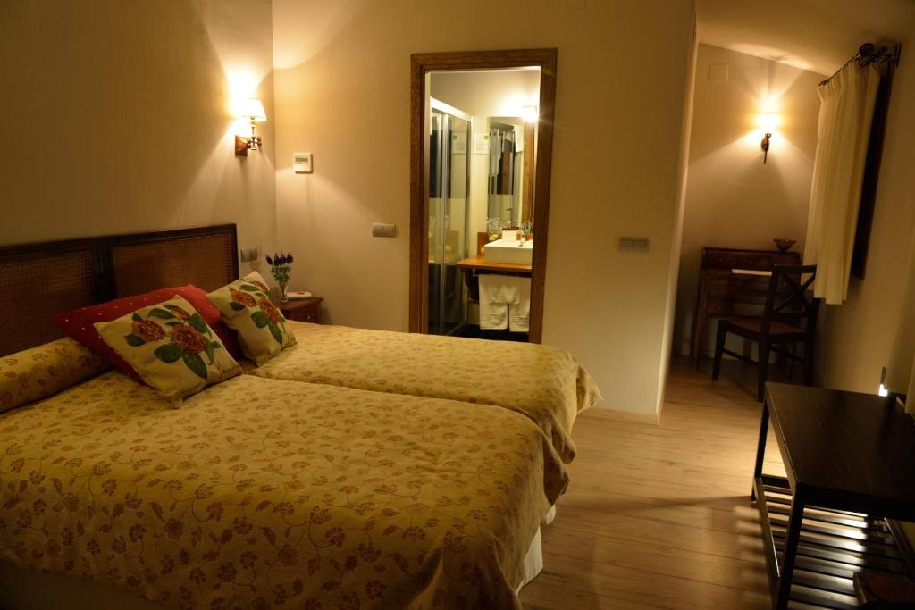 a hotel room with a bed and a bathroom at Casa Rural La Botica in Oropesa