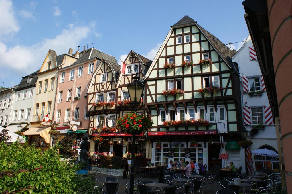 un groupe de bâtiments avec des fleurs devant eux dans l'établissement The Burgklause Boutique Hotel, à Linz am Rhein