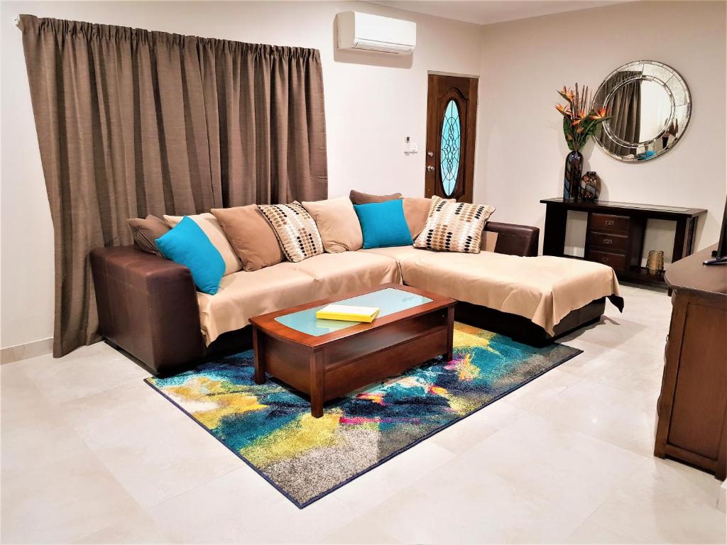a living room with a couch and a table at Darwin Beach Escape Holiday Home in Casuarina