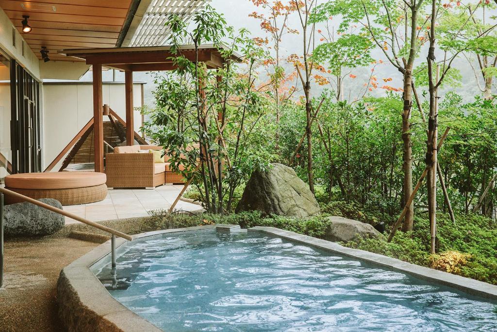 a hot tub in the middle of a garden at Kanaya Hotel Kinugawa in Nikko