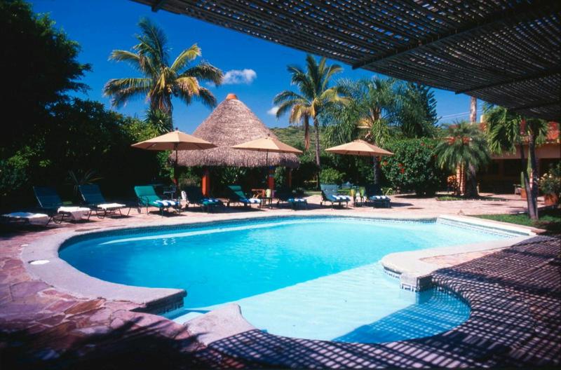 a swimming pool with umbrellas and chairs and a resort at Casa Marly in Xochitepec