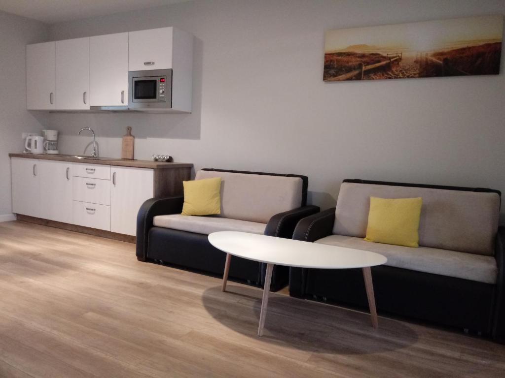 ウストロニエ・モルスキエにあるBumerangのリビングルーム(ソファ2台、テーブル付)、キッチンが備わります。