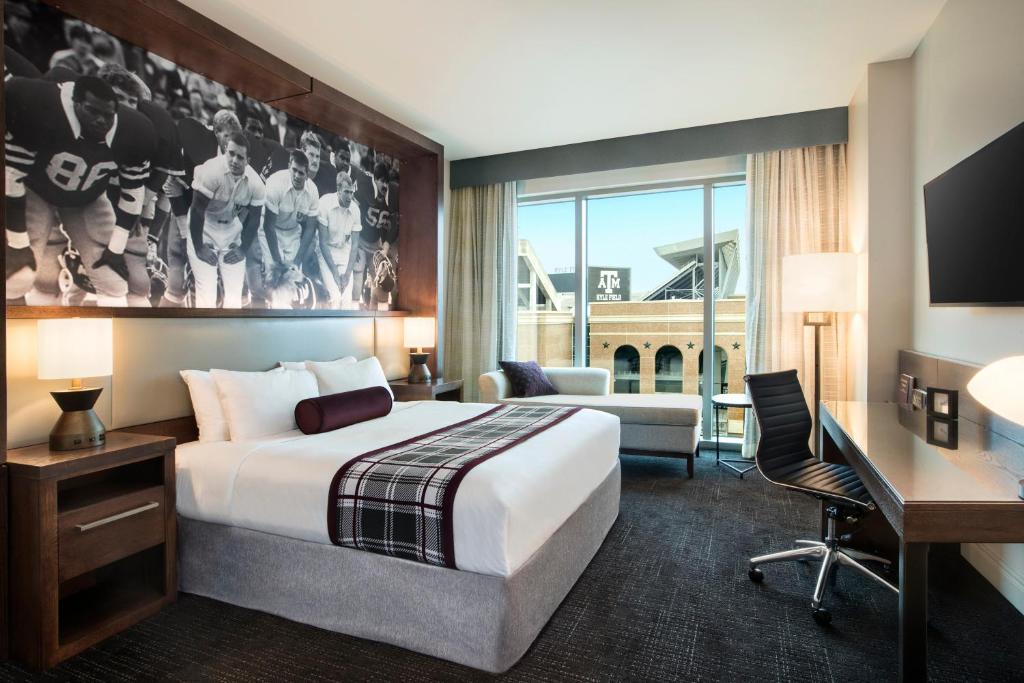 a hotel room with a large bed and a desk at Texas A&M Hotel and Conference Center in College Station