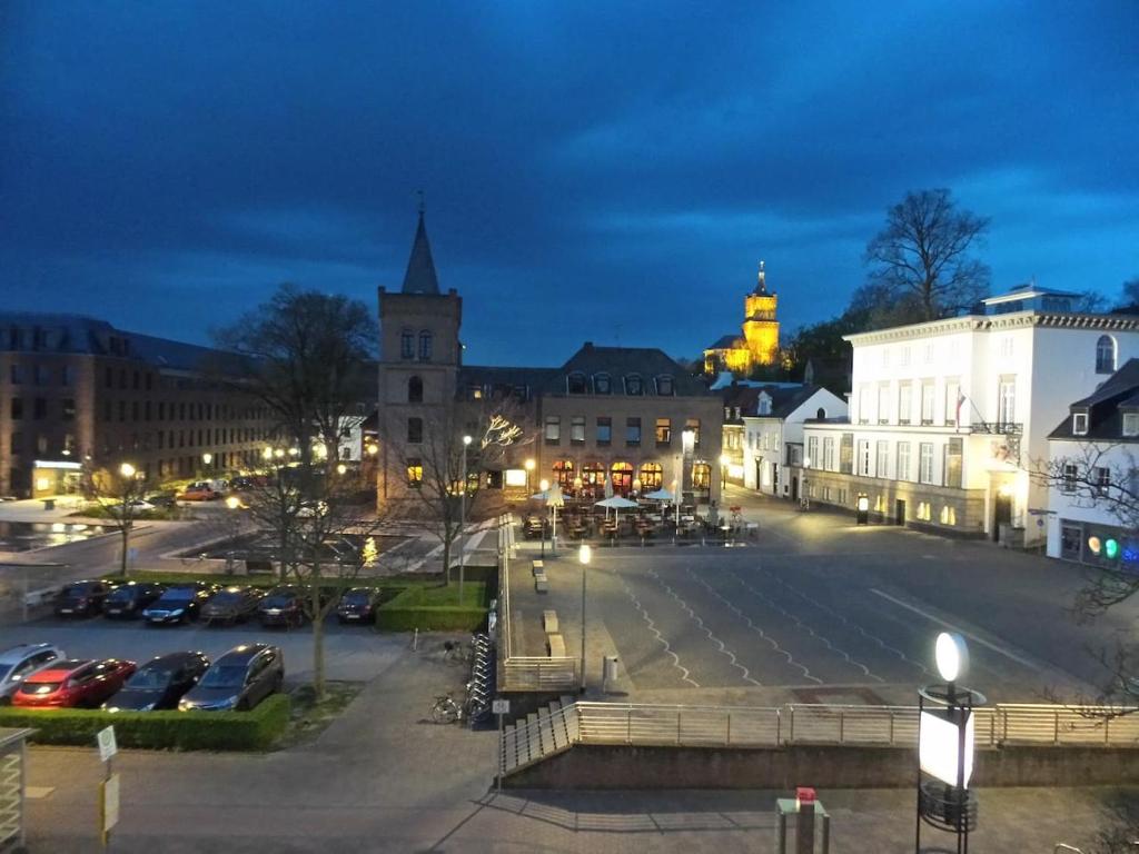 een stad 's nachts met auto's geparkeerd op een parkeerplaats bij Erdgeschosswohnung im Stadtzentrum in Kleve