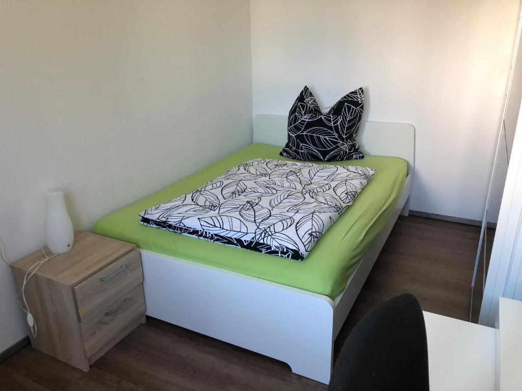 a small room with a bed with a pillow on it at Ferienwohnung Janson in Wiesenbach