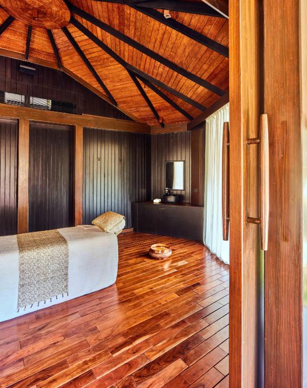 a bedroom with a bed and a wooden floor at Taj Exotica Resort & Spa, Andamans in Havelock Island