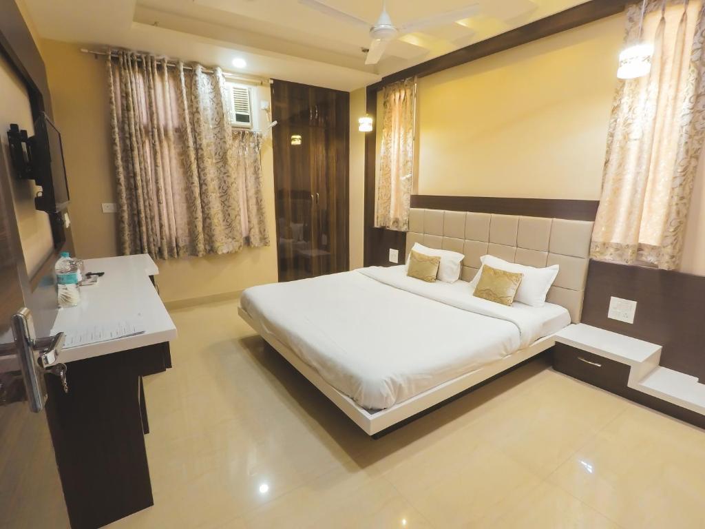 a bedroom with a white bed and a white desk at Travelling Troopers Homestay in Varanasi