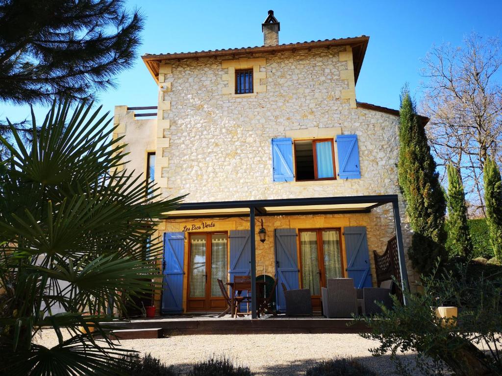 an external view of a stone house with blue windows at Le Mas des Geais in Atur