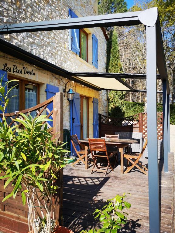 a patio with a table and an umbrella at Le Mas des Geais in Atur