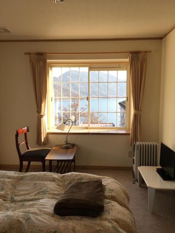 a bedroom with a bed and a large window at Little Forest Inn Nikko in Nikko