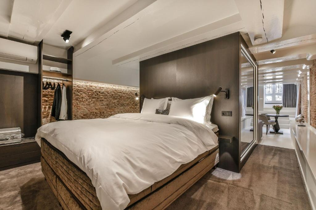 a bedroom with a large bed and a bathroom at Luxury Canal Suite De Heren in Amsterdam