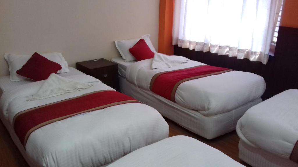 a hotel room with two beds and a window at Rambler Hostel Pvt Ltd in Kathmandu