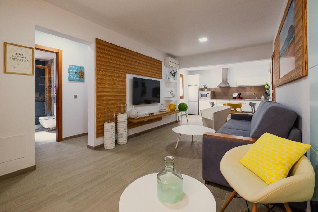 sala de estar con sofá y mesa en La Pardela Exclusive Apartamentos, en Caleta de Sebo