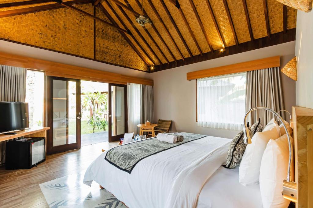 a bedroom with a large bed and a television at Kashantee Village in Seminyak