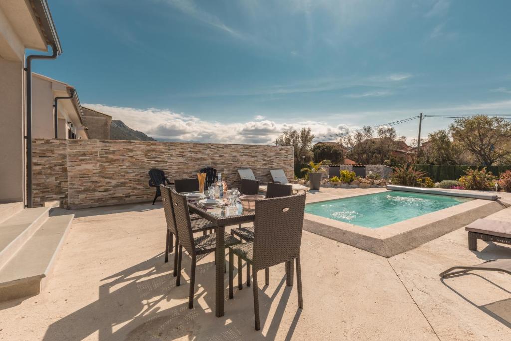 a patio with a table and chairs next to a swimming pool at Le Domaine De Marie in Palasca