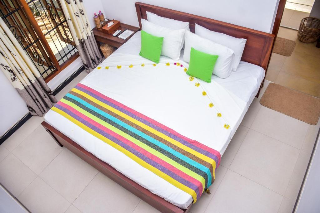 a large bed with colorful blankets and pillows at CASA VACANSA HOME STAY in Hungama