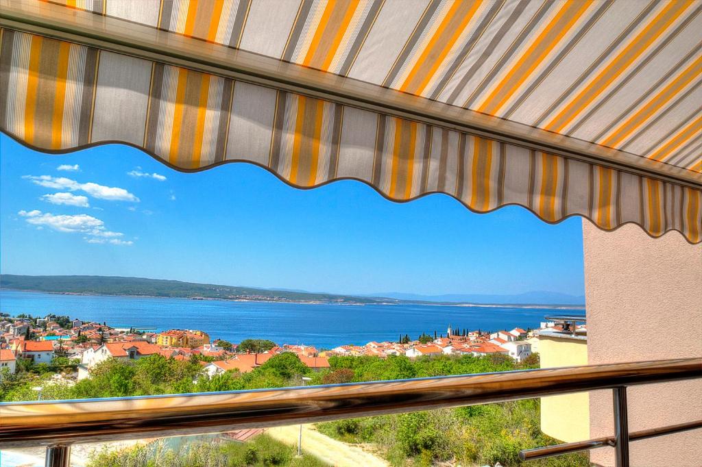a window with a view of a city and the water at Bayview Apartment in Selce