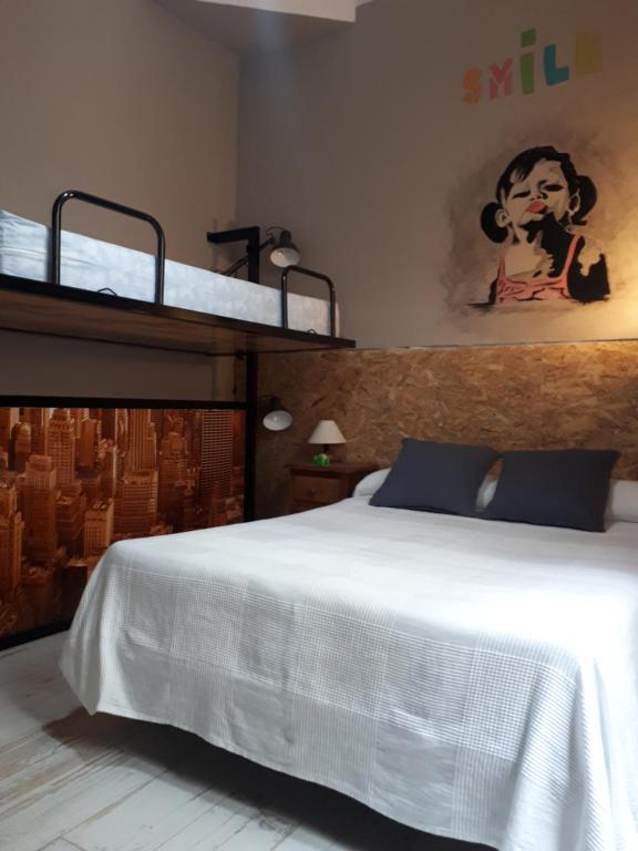 1 dormitorio con 1 cama blanca y 2 literas en Hostal Hispalense, en Madrid