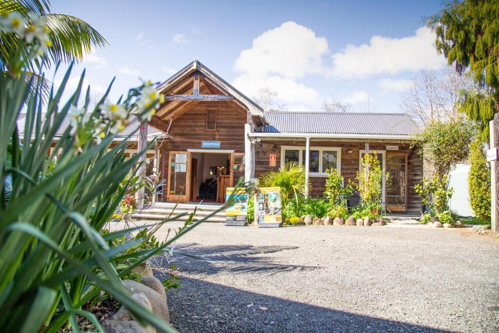 a wooden house with a courtyard in front of it at The Church Accommodation in Hahei