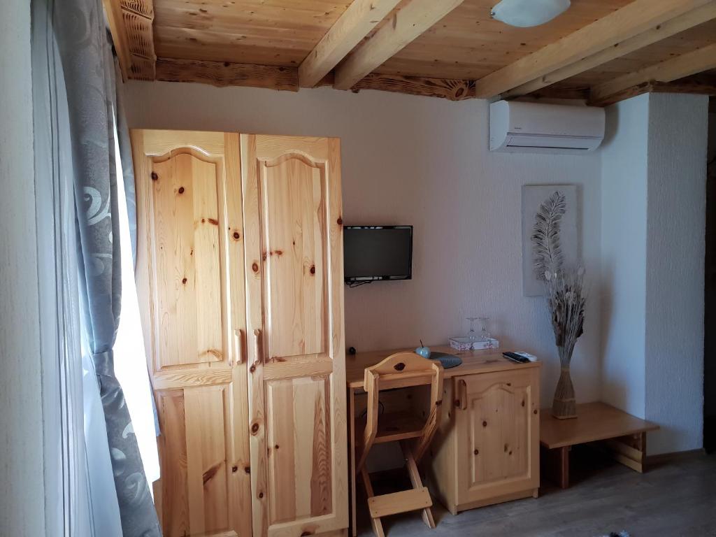 Habitación con armario de madera y escritorio. en Guest House Plitvice Waterfall en Lagos de Plitvice