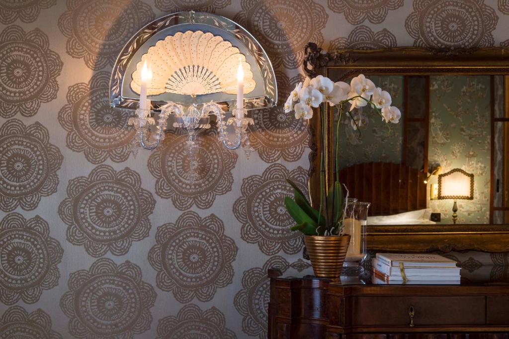 a room with a mirror and a chandelier on a wall at Hotel Metropole Venezia in Venice
