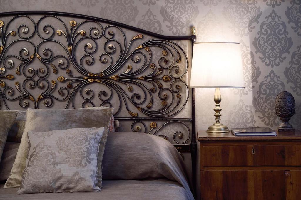 a bedroom with a bed with a headboard and a lamp at Hotel Metropole Venezia in Venice