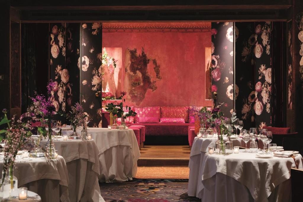 a dining room with two tables and a red couch at Hotel Metropole Venezia in Venice