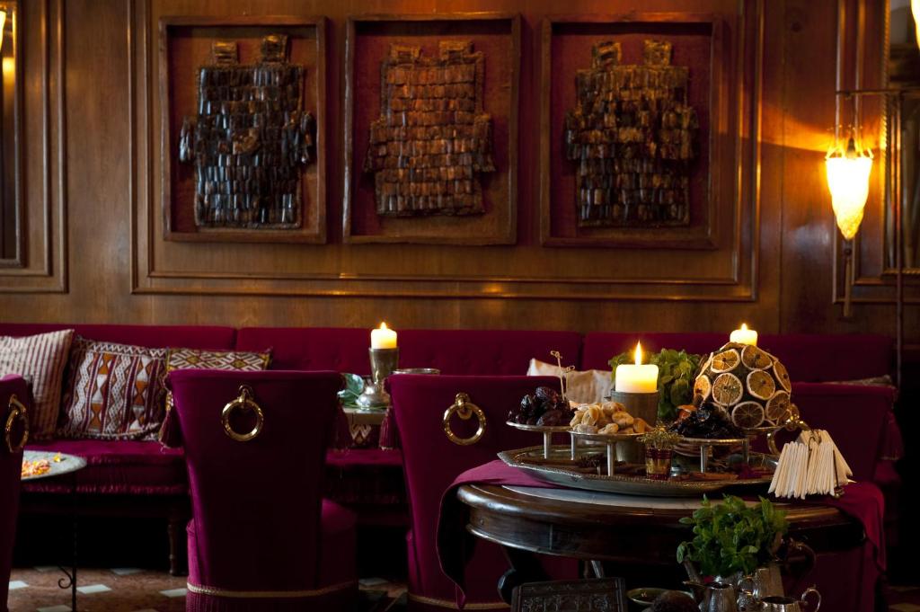 a restaurant with red couches and a table with candles at Hotel Metropole Venezia in Venice