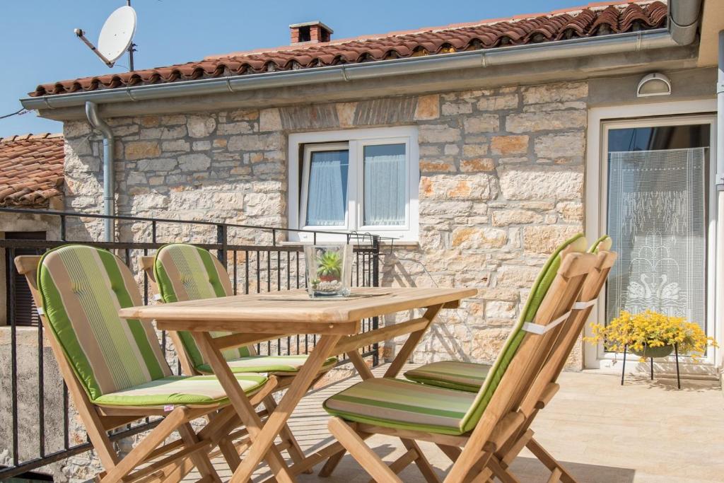 einen Holztisch und Stühle auf dem Balkon in der Unterkunft Apartment Bruneta 1 with Sea View in Vabriga
