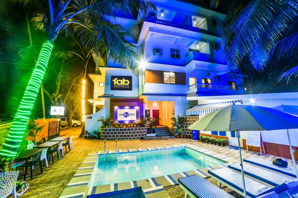 um hotel com piscina em frente a um edifício em FabHotel K7 Trends With Pool, Baga Beach em Calangute