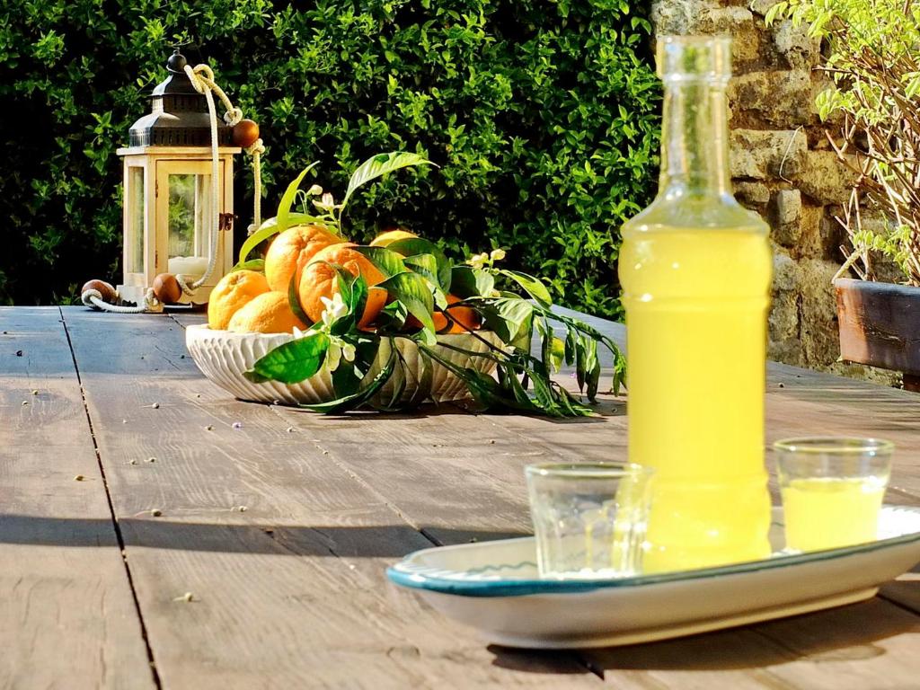 una botella de zumo y un plato de fruta en una mesa en B&B Villa Elisa, en Meta