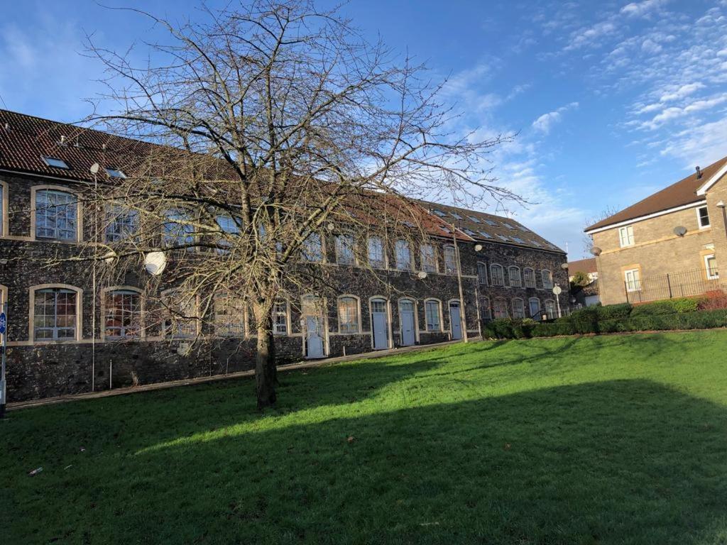 un edificio con un árbol en medio de un patio en Superb Peaceful 1 bed apartment in St George., en Bristol
