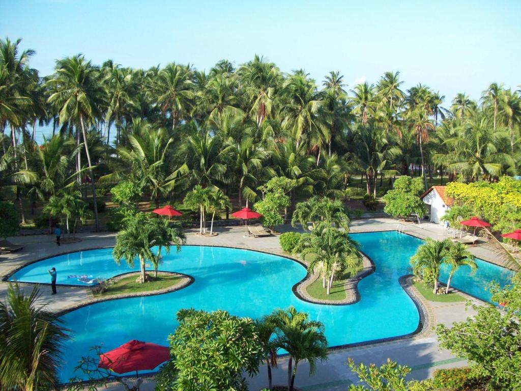 una vista aérea de una piscina del complejo con palmeras en Muine Century Beach Resort & Spa, en Mui Ne