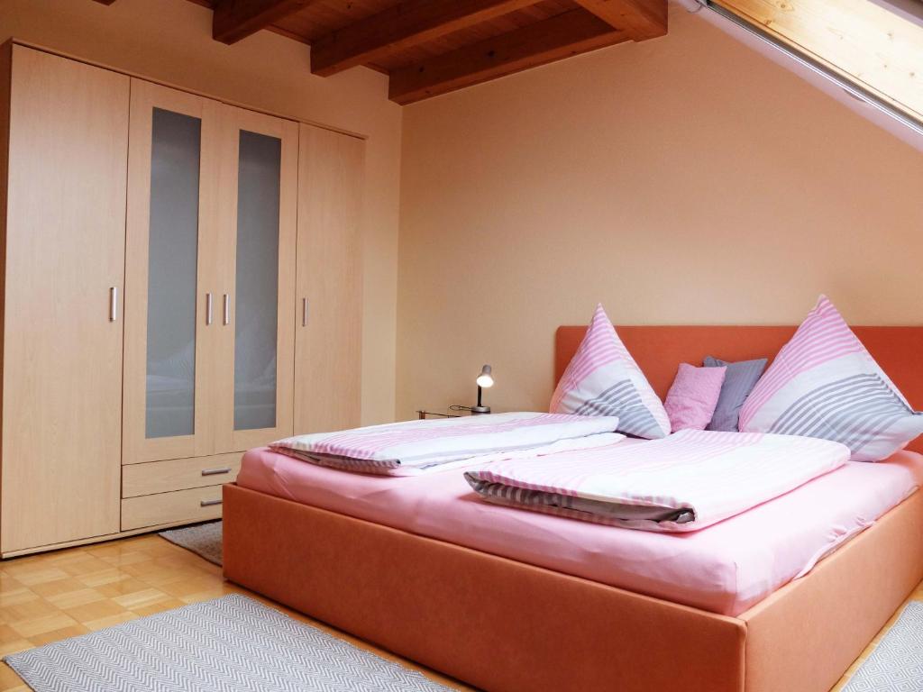 een slaapkamer met een groot bed met witte lakens en kussens bij Haus-Haller in Friedrichshafen
