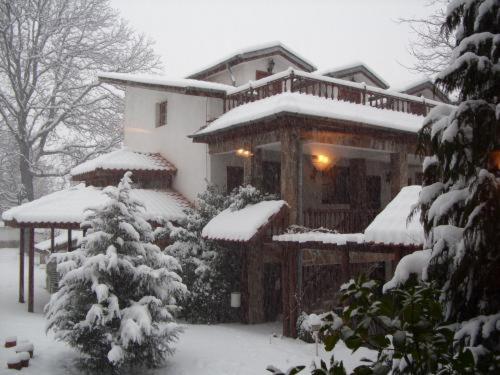 a house covered in snow in front at Hotel Teddy House in Bansko