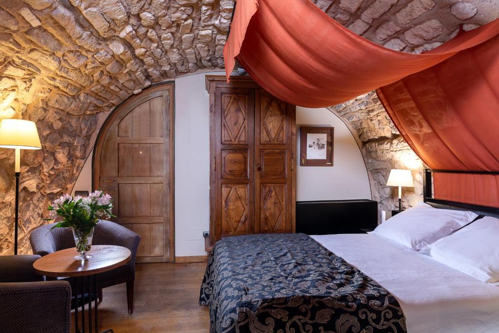 A bed or beds in a room at Parador de Alarcón