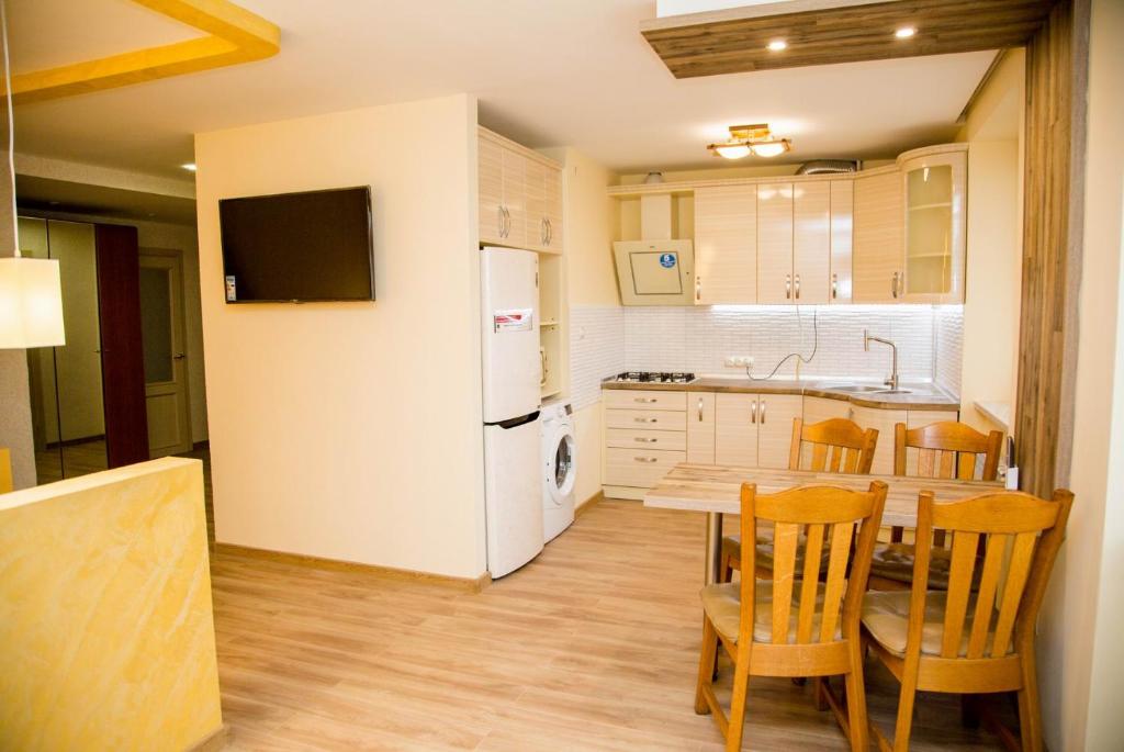 uma cozinha com uma mesa de jantar e um frigorífico branco em Sahara em Berehove