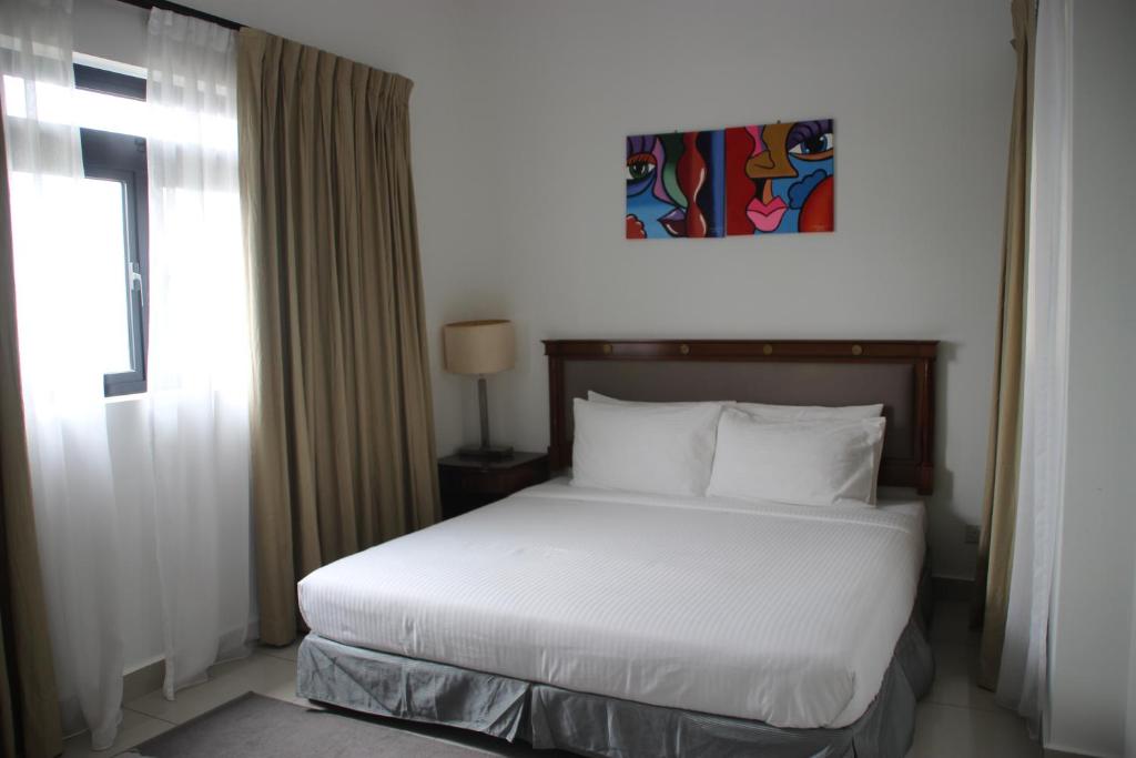 a bedroom with a white bed and a window at Meridin Medini Muslim Condo in Nusajaya