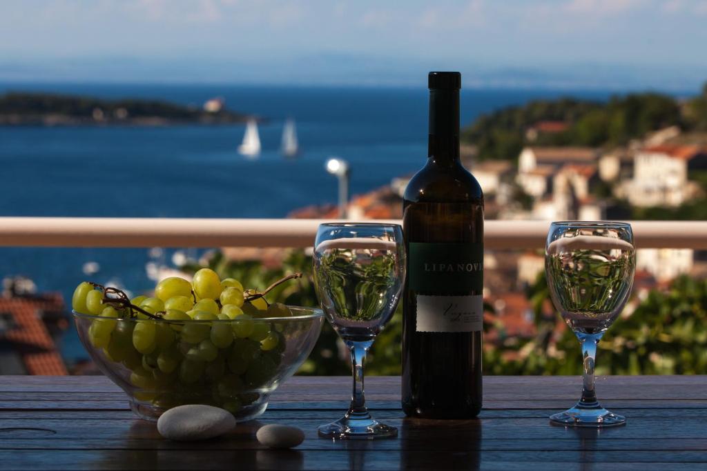 een fles wijn en twee glazen op een tafel bij Villa Kate in Vis