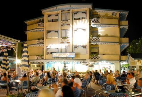 a crowd of people sitting outside of a building at Hotel Maxim in Caorle