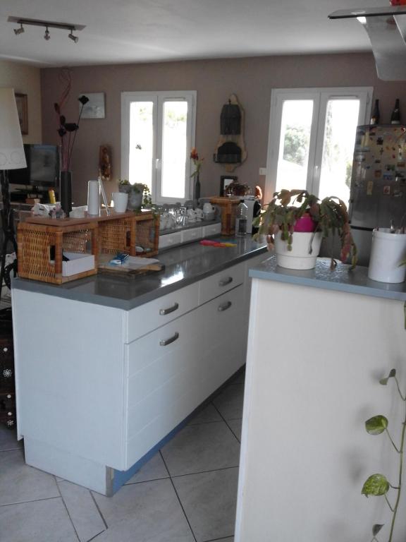 kuchnia z białymi blatami i oknami w obiekcie Soleil, Lavande et Oliviers w mieście Pertuis