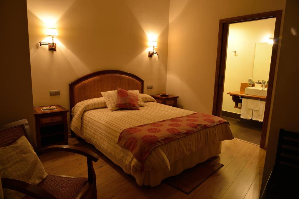 a bedroom with a bed and a bathroom with a sink at Casa Rural La Botica in Oropesa