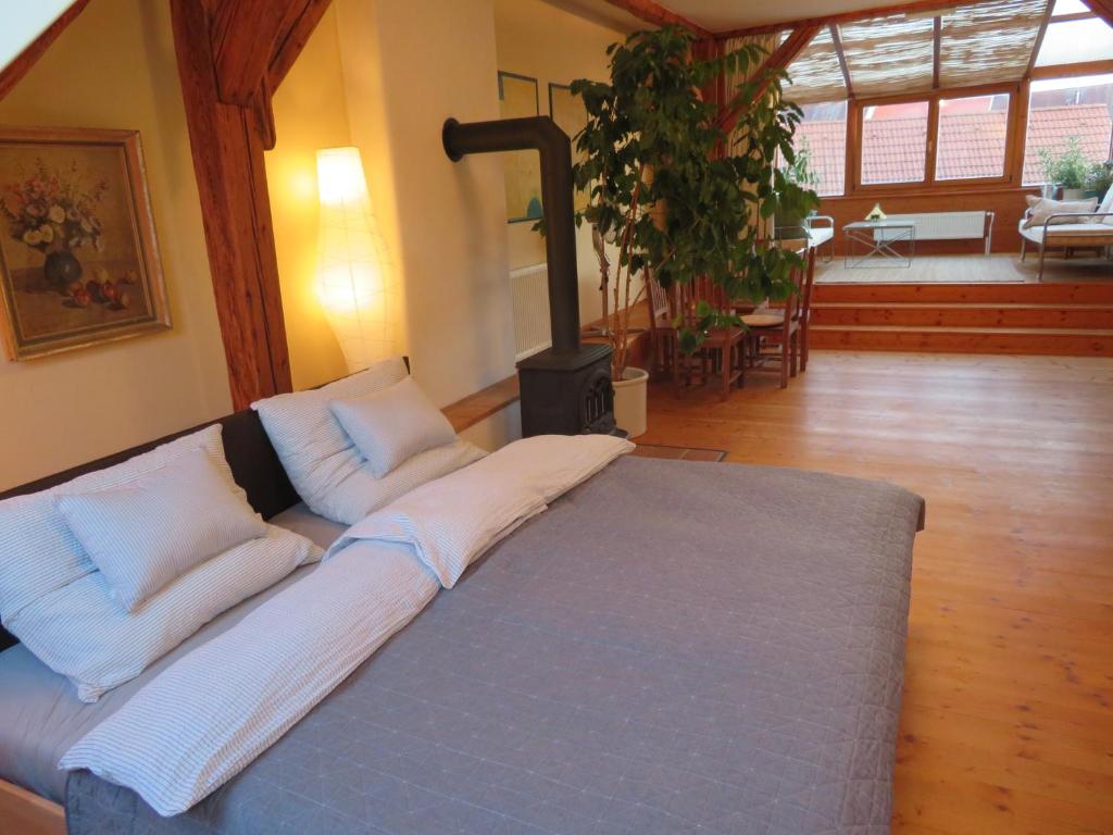 łóżko z białymi poduszkami w pokoju z piecem opalanym drewnem w obiekcie Family Apartment Písek City Centre w Piosku