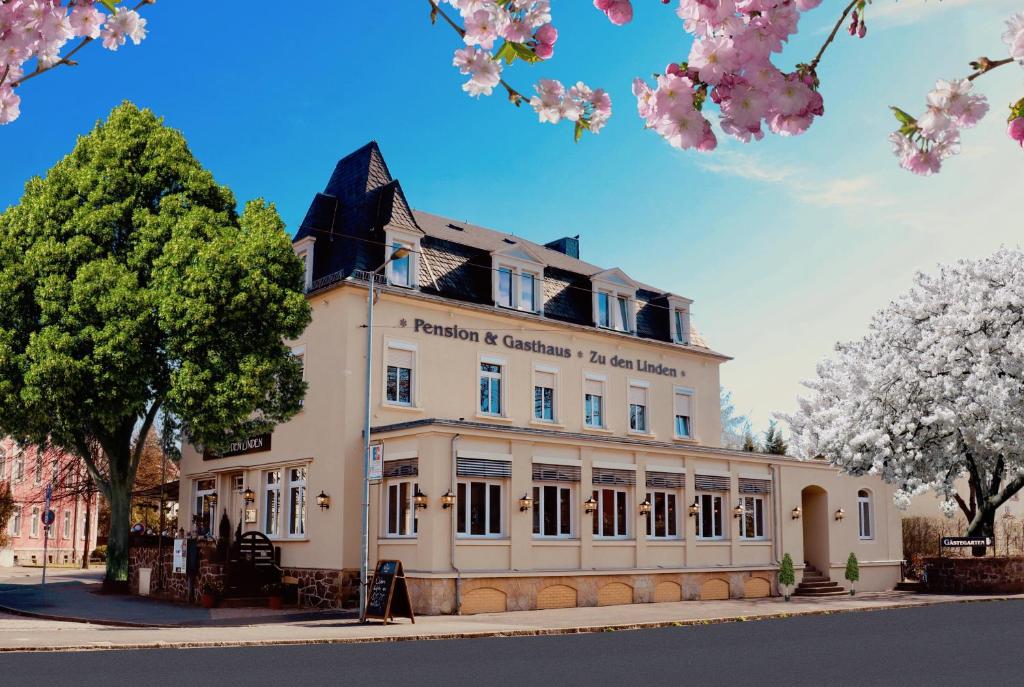 un gran edificio blanco con árboles delante de él en ZU DEN LINDEN - RADEBEUL Pension mit Restaurant en Radebeul