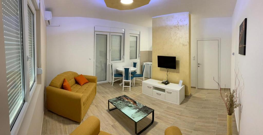 uma sala de estar com um sofá e uma televisão em Airport view Apartment em Belgrado