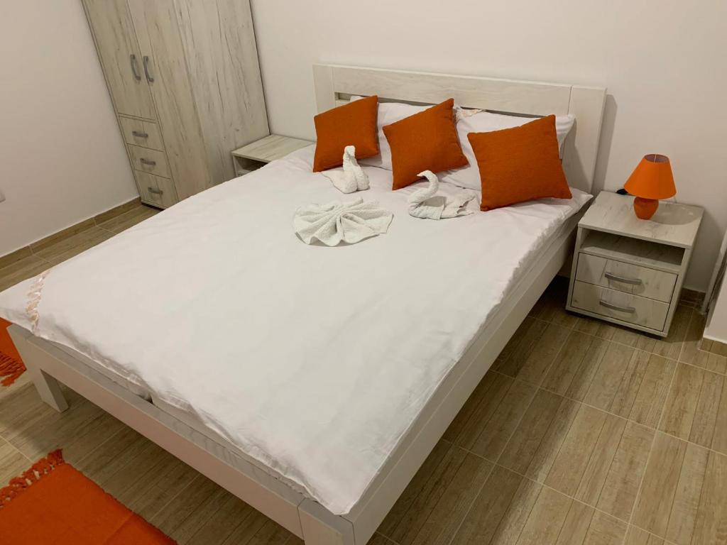 a bedroom with a large white bed with orange pillows at Airport view Apartment in Belgrade