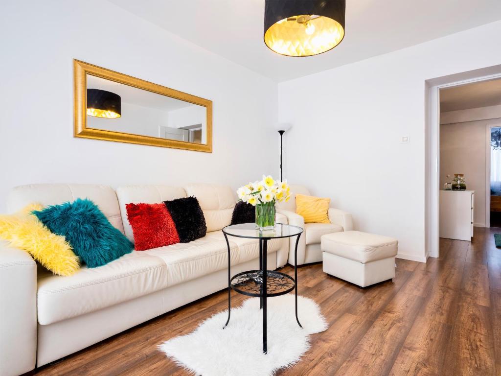 salon z białą kanapą i kolorowymi poduszkami w obiekcie Apartament Kolorowy w Krakowie