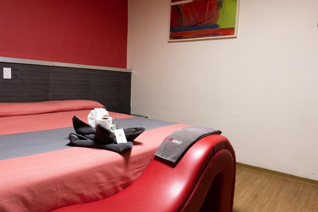 A two-bed room with red-and-gray bedding and a distinctive red chair.