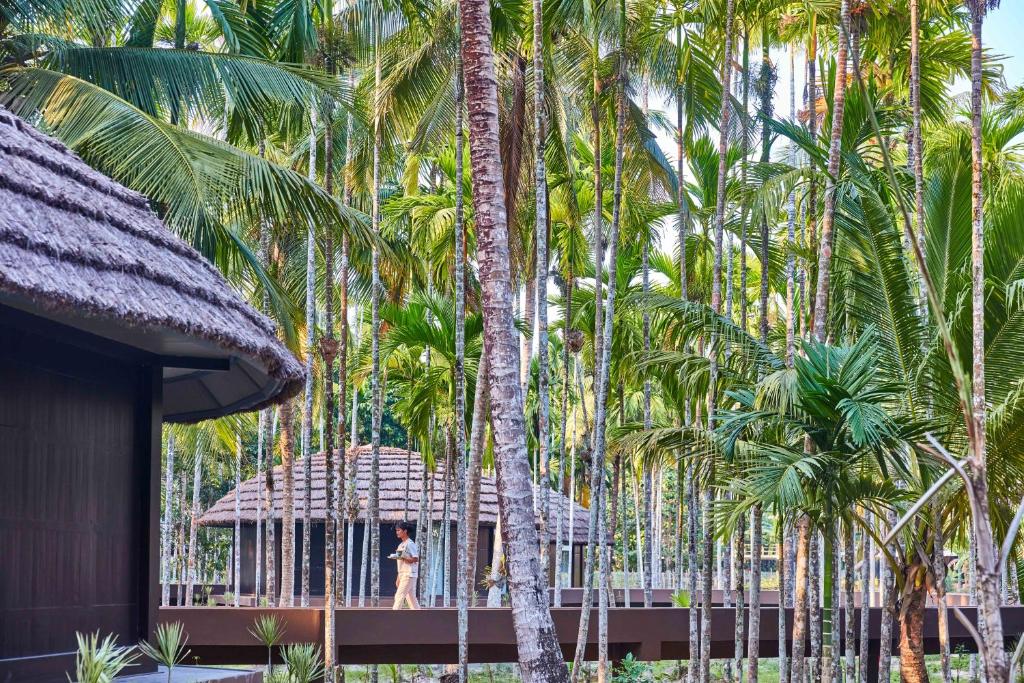 a woman standing in front of a group of palm trees at Taj Exotica Resort & Spa, Andamans in Havelock Island